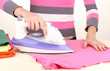 Young woman ironing her clothes, isolated on white