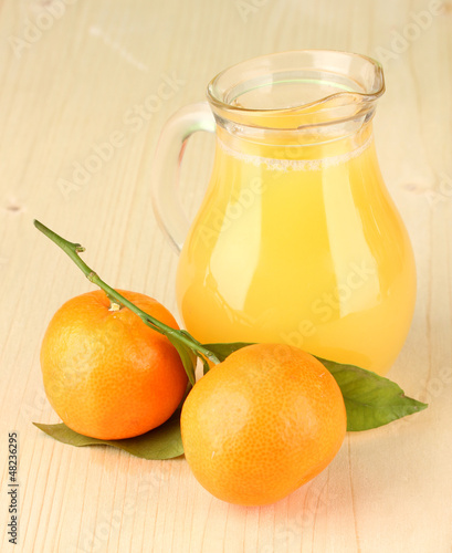 Photo: Full jug of orange juice, on wooden background Full jug of orange juice, on wooden background
