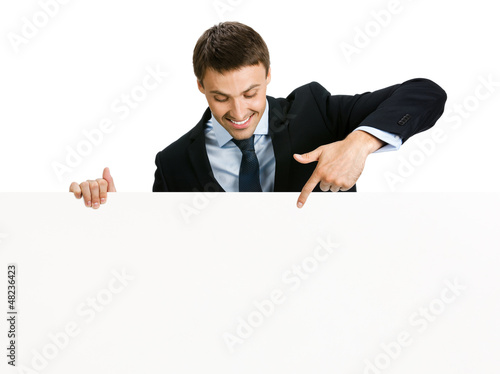 Photo: Happy businessman showing signboard, isolated Happy businessman showing signboard, isolated