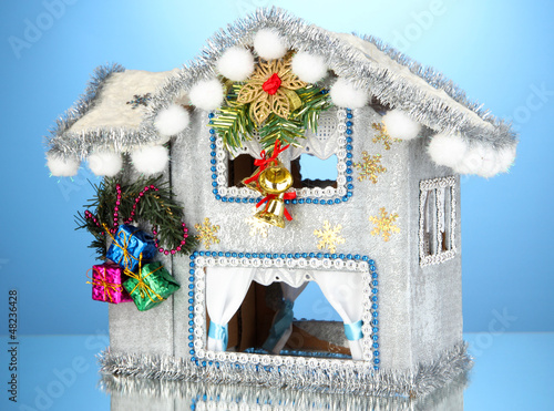 Photo: Decorated Christmas house on blue background Decorated Christmas house on blue background