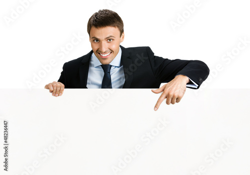 Photo: Happy businessman showing signboard, isolated Happy businessman showing signboard, isolated