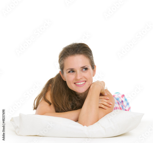 Photo: Happy young woman in pajamas laying on pillow Happy young woman in pajamas laying on pillow