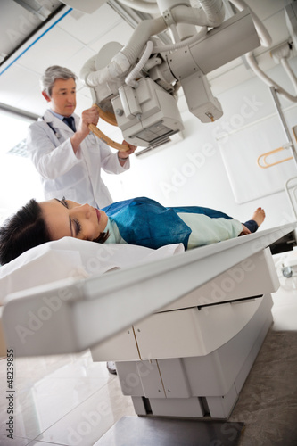 Photo: Radiologist Setting Up Machine To X-ray Female Radiologist Setting Up Machine To X-ray Female