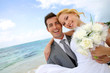 Photo: Groom holding bride in his arms at the beach Groom holding bride in his arms at the beach