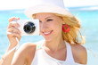 Cheerful girl talking pictures with digital camera