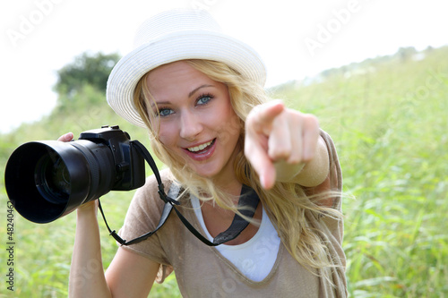Photo: Portrait of adventure girl using photo camera in nature Portrait of adventure girl using photo camera in nature