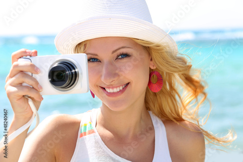 Photo: Cheerful girl talking pictures with digital camera Cheerful girl talking pictures with digital camera
