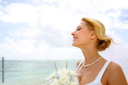 Photo: Portrait of beautiful bride with eyes shut by the beach Portrait of beautiful bride with eyes shut by the beach