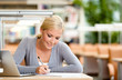 Female student studying on the laptop sitting at the desk