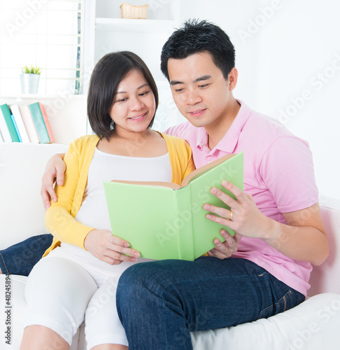 Photo: Asian couple reading book together Asian couple reading book together