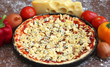 uncooked pizza with ingredients on wooden background, close-up