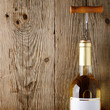 Wine bottle with corkscrew on wooden background
