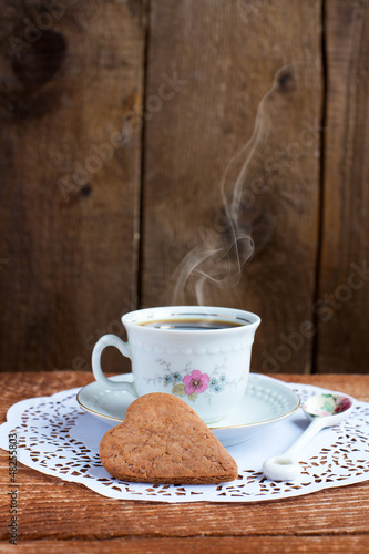 Photo: Heart shape Saint Valentine's Cookie and cup of coffee with stea Heart shape Saint Valentine's Cookie and cup of coffee with stea