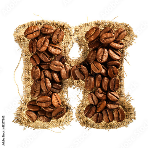 Photo: Alphabet from coffee beans on fabric texture isolated on white Alphabet from coffee beans on fabric texture isolated on white