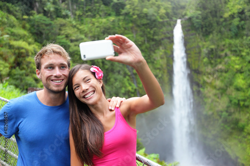 Photo: Couple tourists taking self portrait on Hawaii Couple tourists taking self portrait on Hawaii