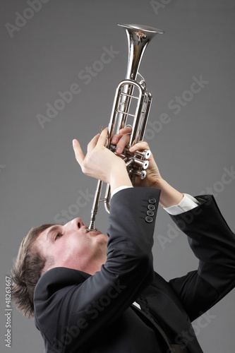 Photo: Portrait of a young man playing his Trumpet Portrait of a young man playing his Trumpet