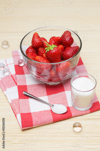 Photo: Fresh strawberries and sugar in glass bowls Fresh strawberries and sugar in glass bowls