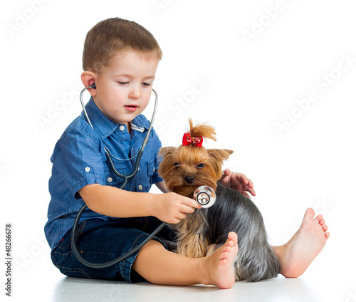 Photo: boy child examing dog puppy isolated on white background boy child examing dog puppy isolated on white background