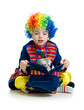 Boy clown with kitten inside hat over the white background