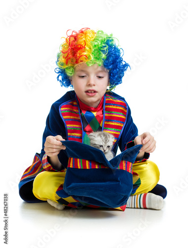 Photo: Boy clown with kitten inside hat over the white background Boy clown with kitten inside hat over the white background