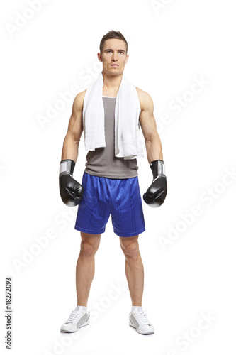 Photo: Young man in sports outfit wearing boxing gloves Young man in sports outfit wearing boxing gloves