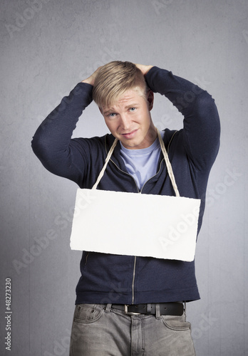 Photo: Devastated man showing white empty signboard. Devastated man showing white empty signboard.