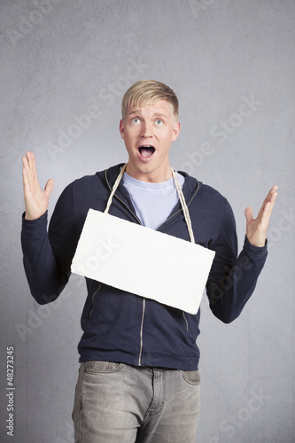 Photo: Shocked concerned man showing empty signboard. Shocked concerned man showing empty signboard.