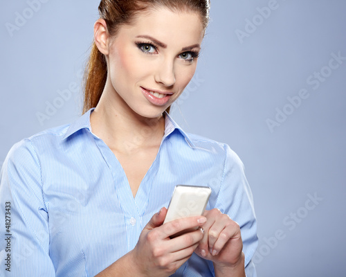 Photo: Happy smiling successful businesswoman with cell phone. Happy smiling successful businesswoman with cell phone.