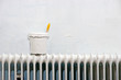 with white paint and paintbrush on radiator