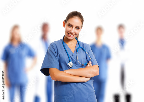Photo: Beautiful nurse in front of her medical team Beautiful nurse in front of her medical team