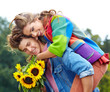 Foto: Loving young man hugging his girlfriend with sunflowers in their Loving young man hugging his girlfriend with sunflowers in their