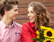 Foto: Loving young man hugging his girlfriend with sunflowers in their Loving young man hugging his girlfriend with sunflowers in their