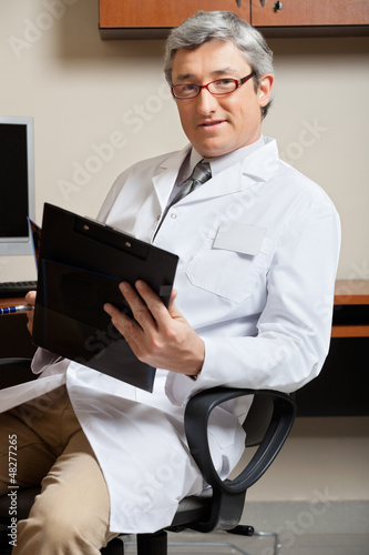 Photo: Mature Doctor Holding Clipboard Mature Doctor Holding Clipboard