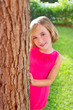 child happy girl smiling rear tree trunk in garden