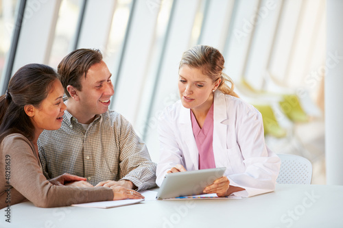 Photo: Female Doctor Using Digital Tablet Talking With Patients Female Doctor Using Digital Tablet Talking With Patients