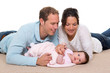 Photo: Baby mother and father happy family lying on carpet Baby mother and father happy family lying on carpet
