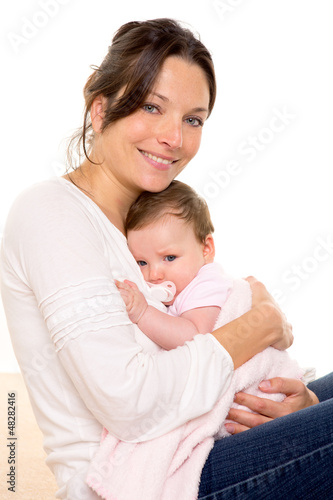 Photo: Baby girl relaxed with pacifier hug in mother arms Baby girl relaxed with pacifier hug in mother arms
