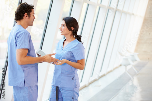 Photo: Medical Staff Talking In Hospital Corridor With Digital Tablet Medical Staff Talking In Hospital Corridor With Digital Tablet