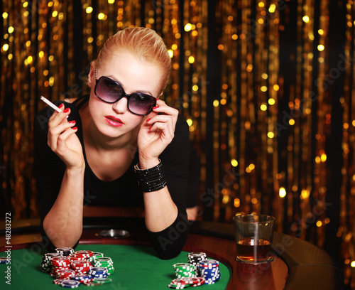 Photo: Frau mit Zigarette spielt Poker Frau mit Zigarette spielt Poker