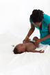 african american mother changing baby's diaper