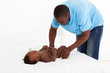 african american father changing baby's diaper