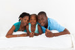happy african american family lying on bed