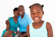 happy african american little girl standing in front of parents