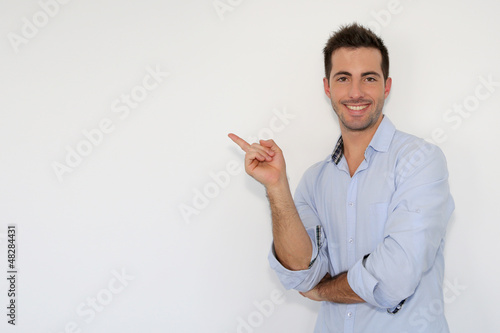 Photo: Cheerful young man showing message on whiteboard Cheerful young man showing message on whiteboard