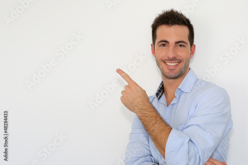 Photo: Cheerful young man showing message on whiteboard Cheerful young man showing message on whiteboard