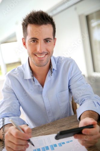 Photo: Man working from home on smartphone Man working from home on smartphone