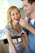 Woman tasting italian sauce cooked by boyfriend