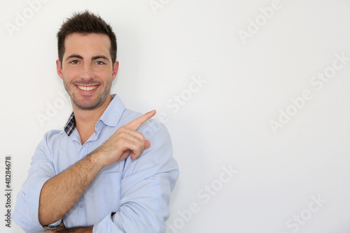 Photo: Cheerful young man showing message on whiteboard Cheerful young man showing message on whiteboard
