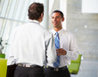 Two Businessmen Having Informal Meeting In Modern Office
