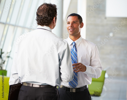 Photo: Two Businessmen Having Informal Meeting In Modern Office Two Businessmen Having Informal Meeting In Modern Office